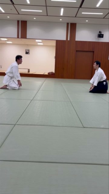 【片手持ち正面当て入身投げ(呼吸投げ)】 片手持ち正面当て入身投げ(呼吸投げ)の稽古を行いました。 相手に片手を掴まれた瞬間、掴まれた手を下横方向に払うと同時に相手の側面へ踏み込み、入身によって相手の体勢を崩します。 さらに、空いている手で相手の面(顎)に向けて掌底の当身を入れ、次の攻撃を封じながら後方へ崩します。掌底を入れた側の後ろ足を前進させ、その動きと一体となって相手を後方へ投げます。 大切なのは、手だけで技をかけるのではなく、入身・当身・足の運びを連動させ、全身の動きで相手を崩すことです。 型では相手を投げますが、護身術として考えた場合、必ずしも投げることが目的ではありません。状況に応じて相手を壁に押し付けたり、突き放して距離を確保したりすることで、危険から離脱するための時間と機会をつくります。 技をかけることだけでなく、危険を回避し、安全な場所へ離れることまでを考える。 宇宙の会では、技の理合を学ぶとともに、護身につながる身体の使い方を大切に稽古しています。 #合気道 #宇宙の会 #片手持ち正面当て #入身投げ #呼吸投げ #護身術 #合気道稽古 #港区 #港区スポーツセンター #田町駅
